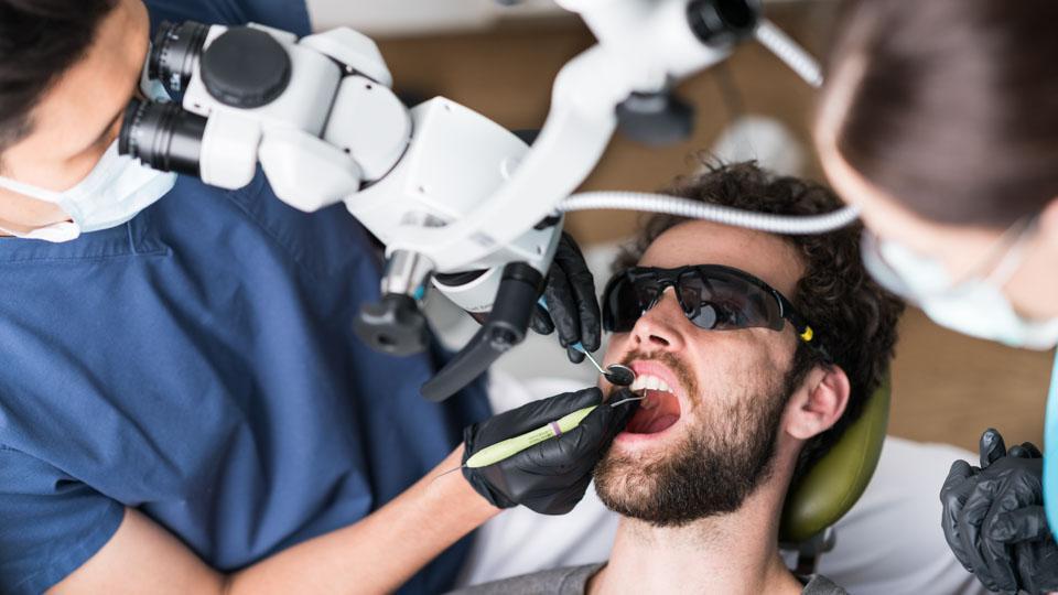 Erikoishammaslääkäri Amemori korjaa hammasta mikroskoopilla. 